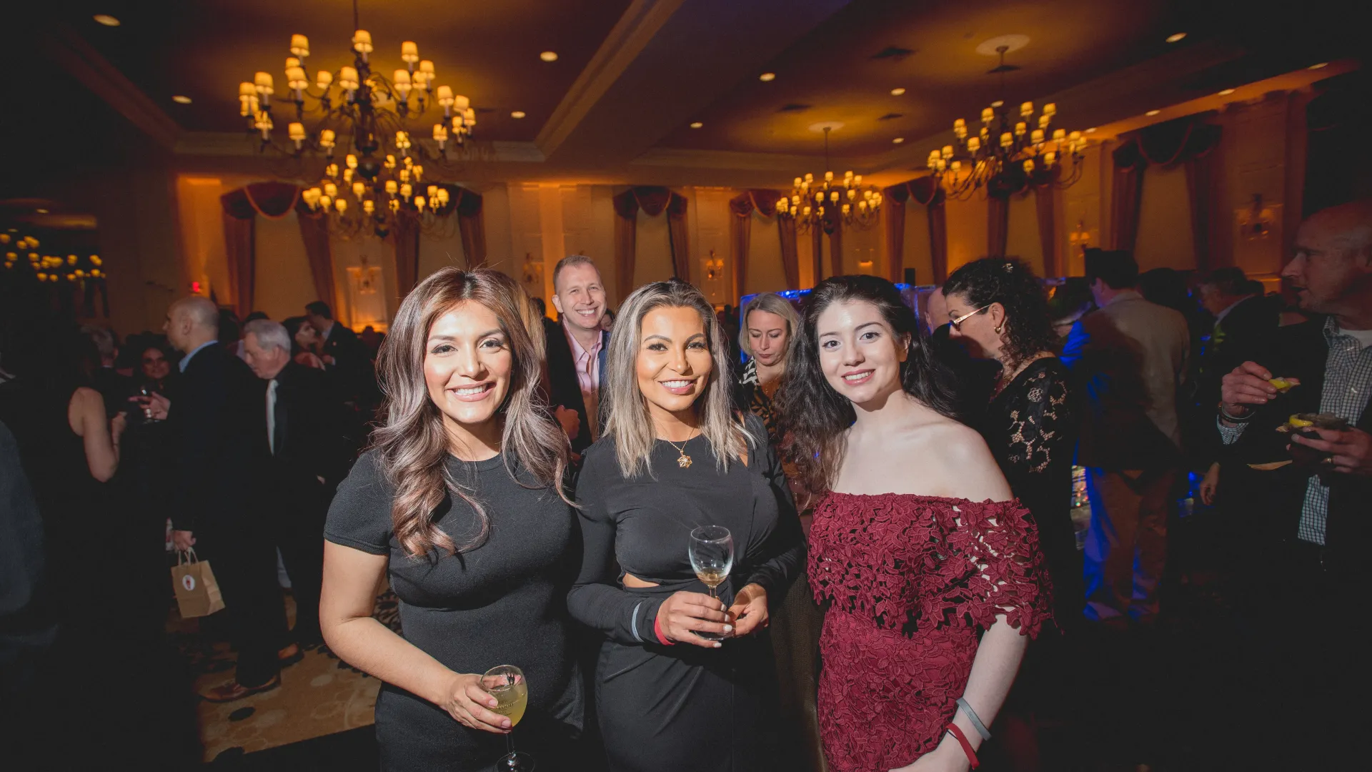 Three women standing in ballroom.