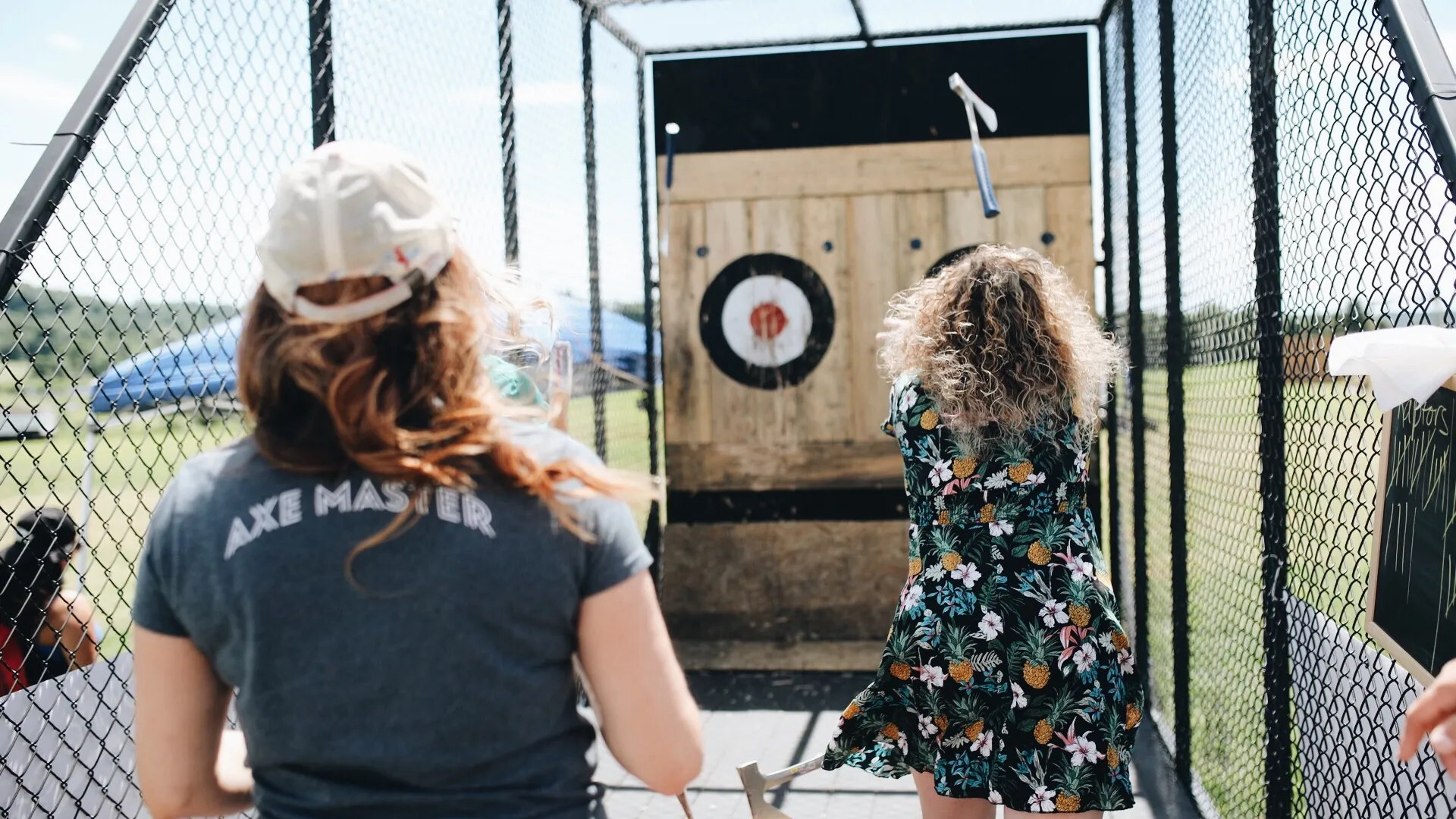 Woman throwing axe at target.