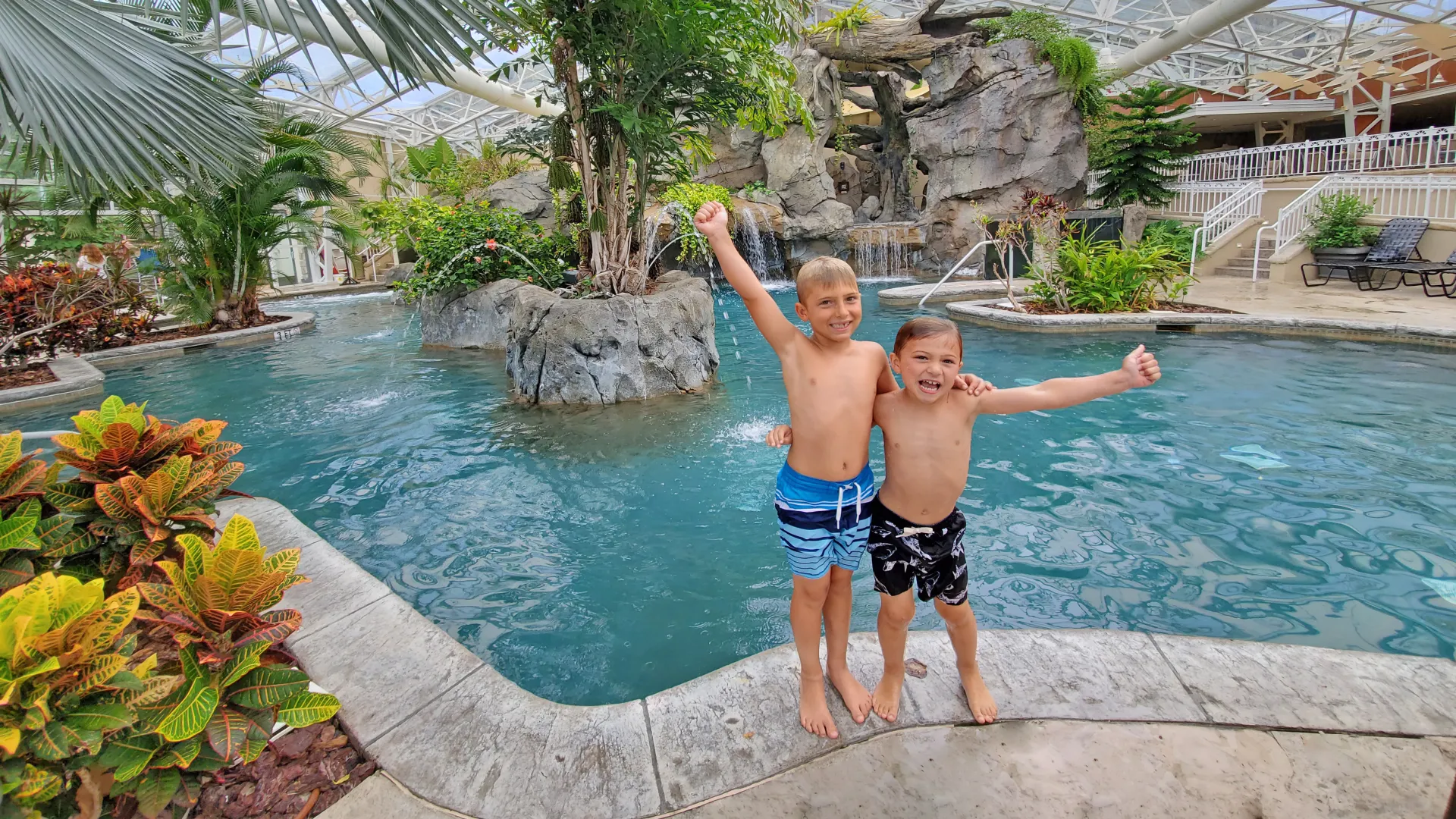 Two boys with their arms around eachother standing outside Biosphere pool.