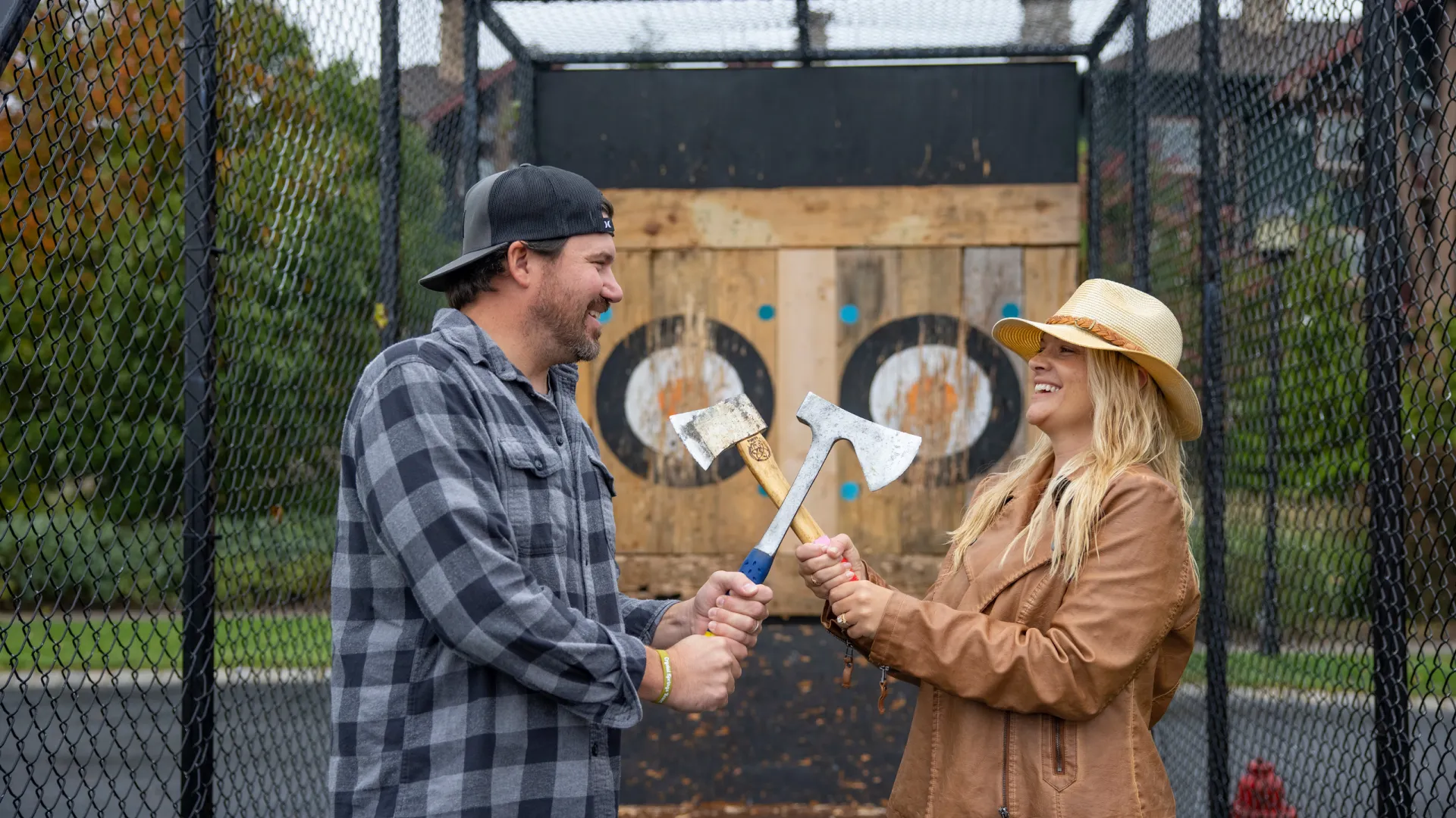 Man and woman axe throwing during their couples retreat.