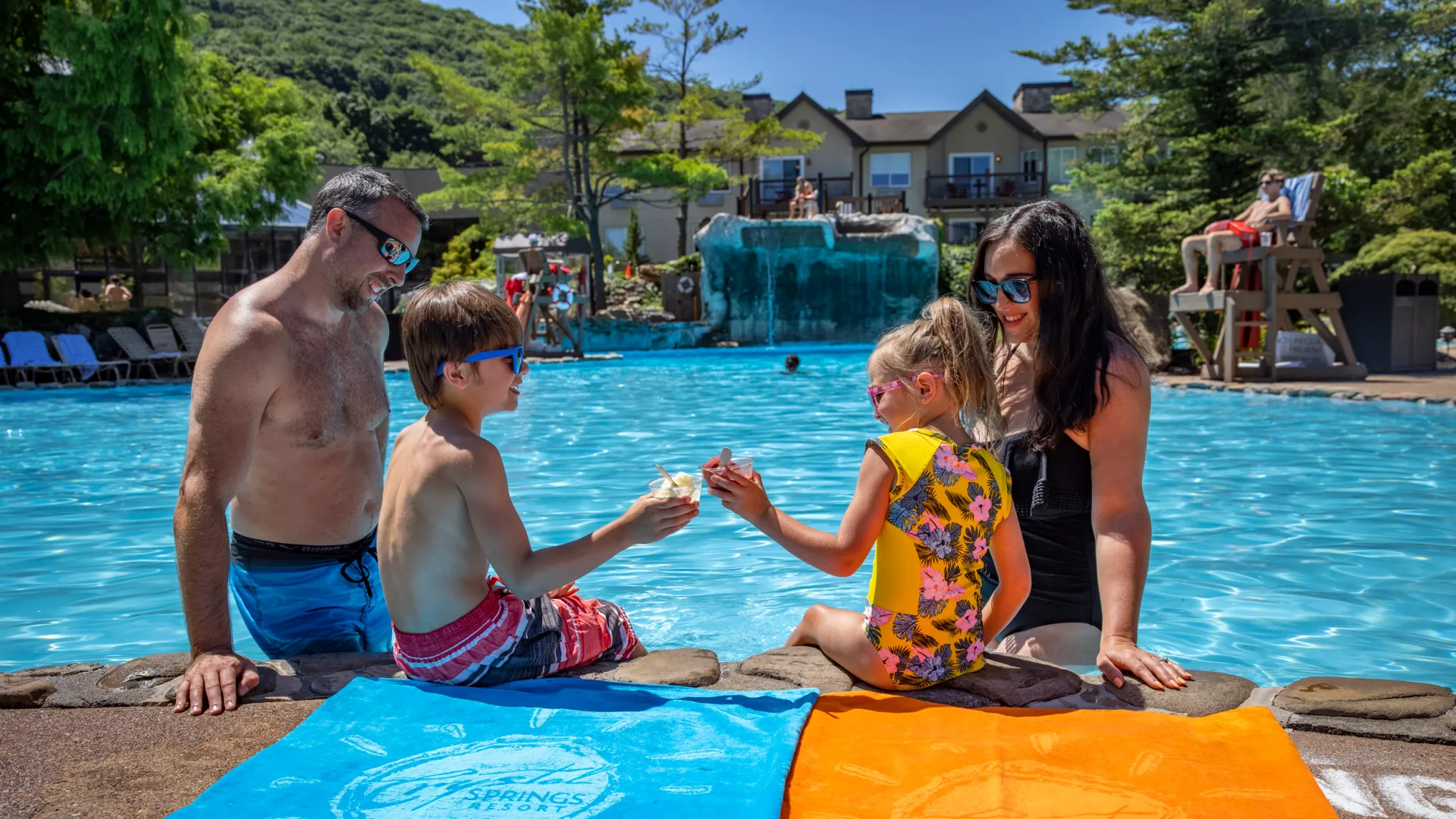 Children enjoying ice cream by the pool with their parents at Minerals Hotel