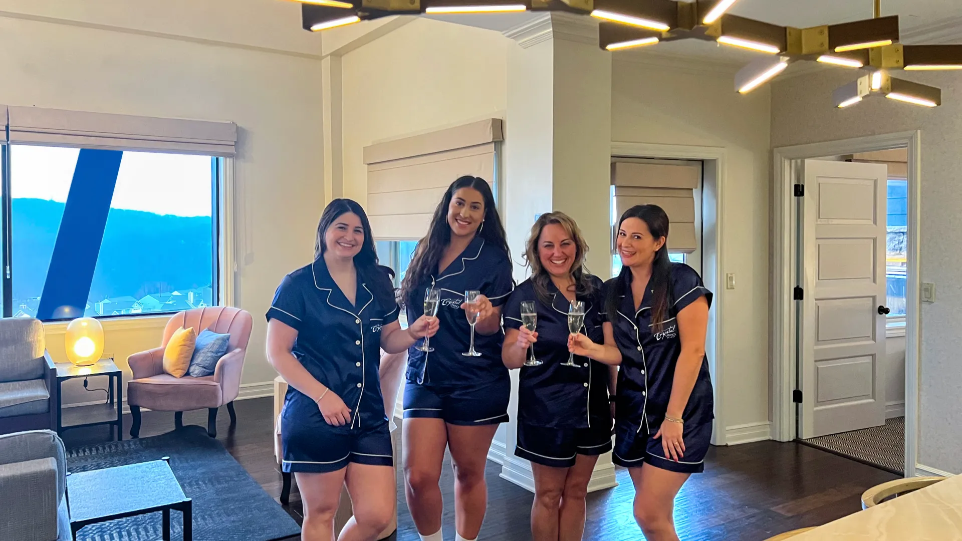 Four girlfriends enjoying a getaway with Crystal Springs PJs and prosecco