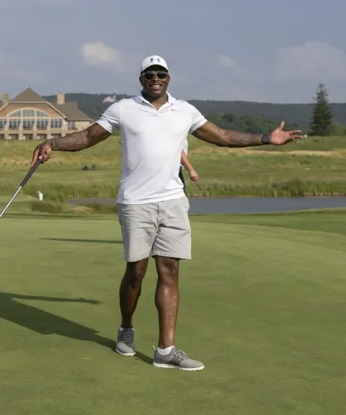 Golfer with arms raised out wide. 