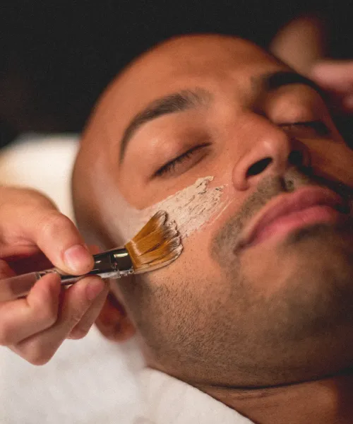 Mask being applied to man's face during facial