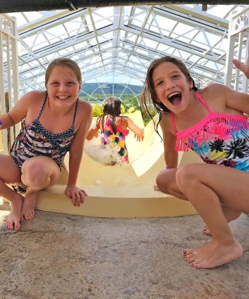 Two girls at top of Biosphere pool complex indoor slide.