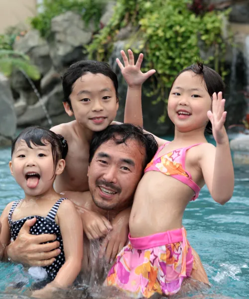 Three children and father in biosphere pool complex.