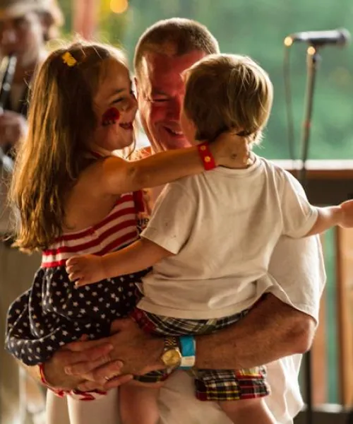 Father dancing with children to band