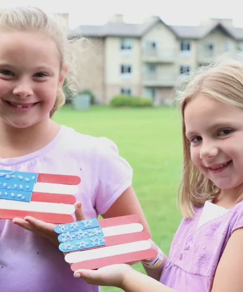 Two girls holding a handmade american flag craft