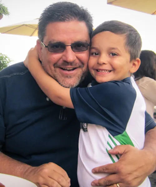 Young child hugging man.