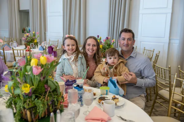 Family of four sitting at table in Emerald Ballroom for Mother's Day.