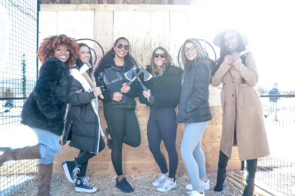 Group of girlfriends participating in axe throwing.