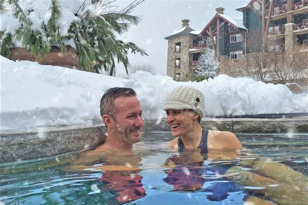 Couple enjoying the snow pool at Grand Cascades Lodge