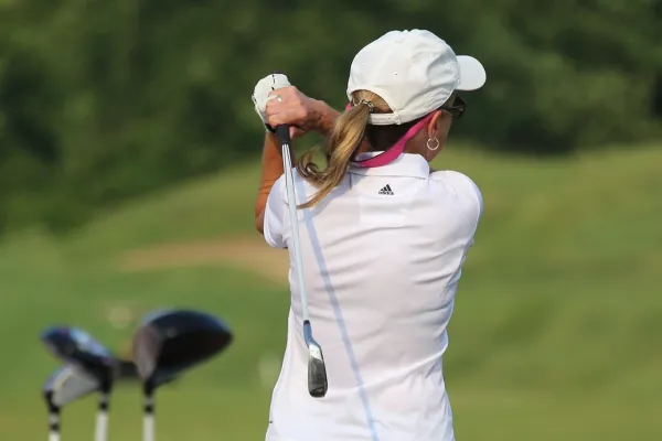 Women in white shirt golfing at a driving range at Crystal Springs Resort