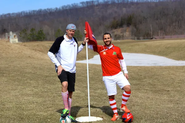 Guys standing on a foot golf hole flag
