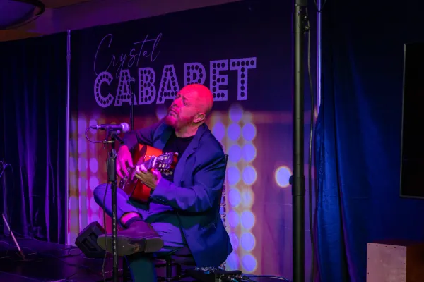 Hernan Romero playing guitar on stage at Crystal Cabaret.