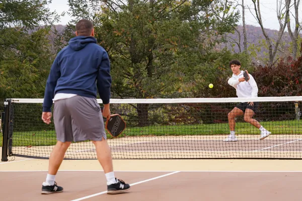 Two boys playing pickleball.