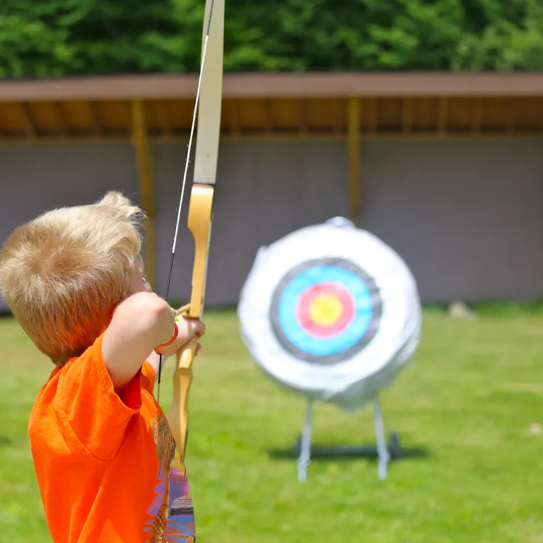 Boy shooting an arrow at a target. 