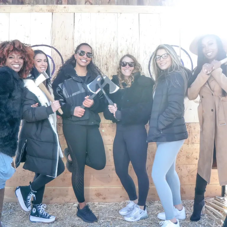 Group of girlfriends participating in axe throwing.