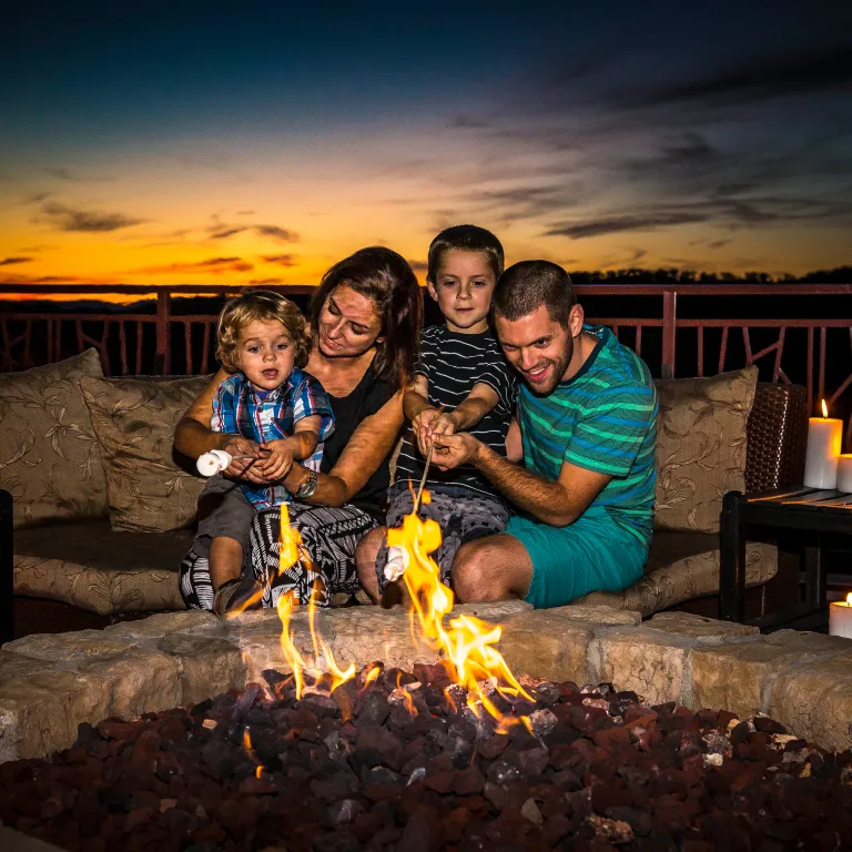 Family roasting marshmallows on the Fire and Water Terrace at Grand Cascades Lodge.