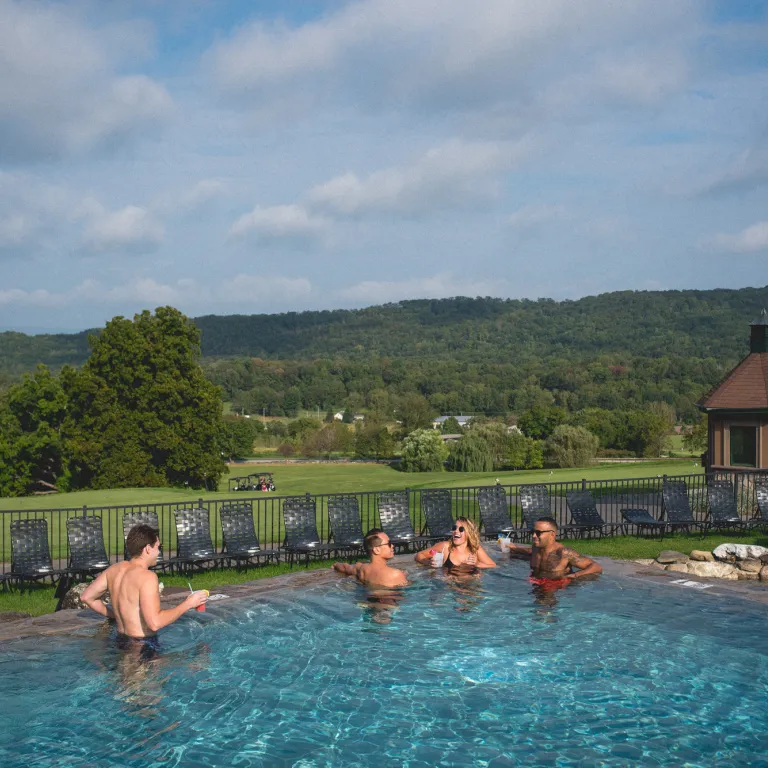 Group of friends relaxing in Vista 180 pool.