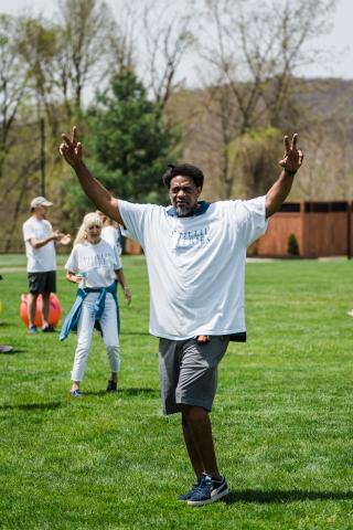 Man raises arms in the air.