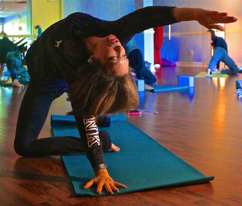 Woman reaching arm backwards during yoga.