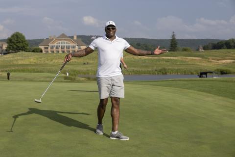 Golfer with arms raised out wide. 