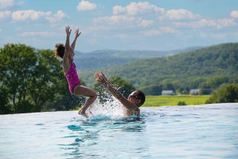 Man throws child in air in Vista pool.