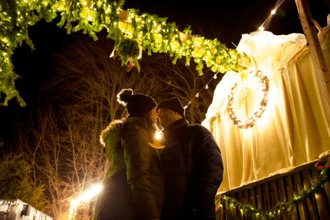 Man and woman sharing kiss under mistletoe at Frosty's Cantina