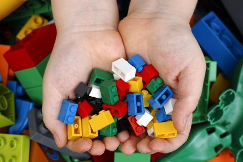 Two hands holding array of colorful legos.