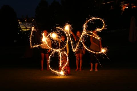 People using sparklers to write LOVE in the air. 