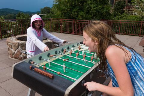 Two children playing foosball.