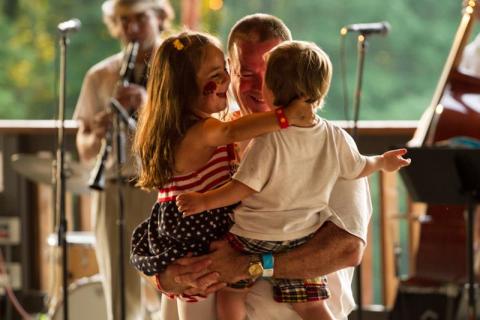 Father dancing with children to band