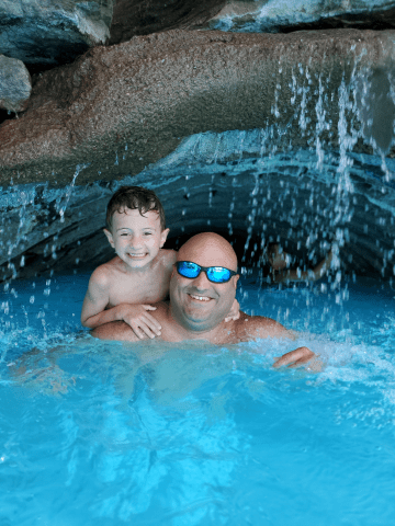 Father and Son under waterfall at minerals pool