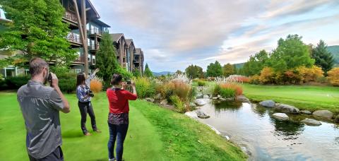 Three people taking photos of the mountains from Crystal Springs Resort