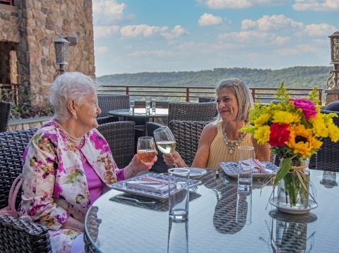 Mother and daughter making a toast with glasses of wine