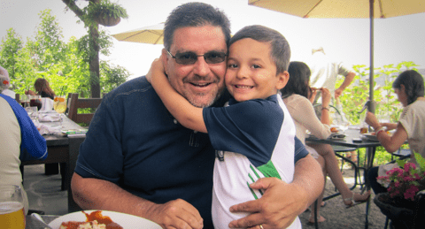 Young child hugging man.