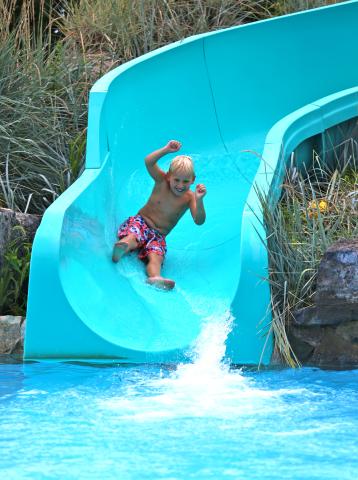 Boy sliding down pool slide at vista 180.