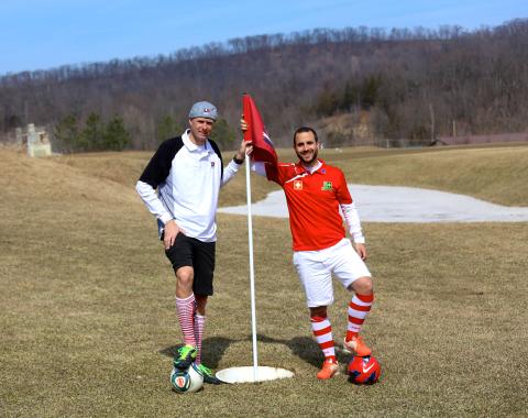 Guys standing on a foot golf hole flag