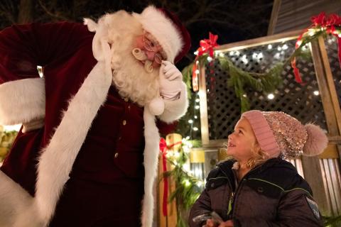 Santa looking down at little girl.