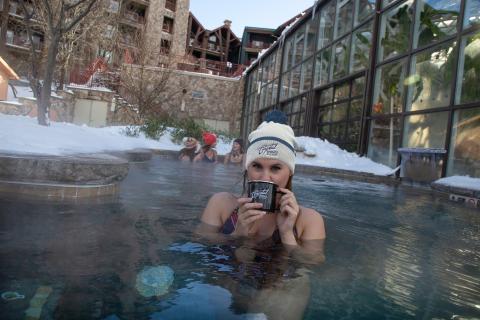 Woman enjoying hot chocolate in the snow pool