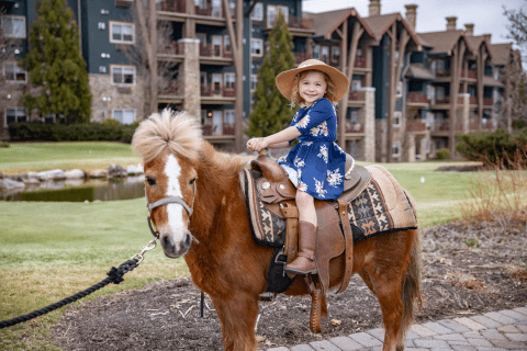 Young girl riding a pony during family vacation.