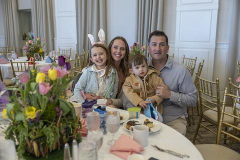 Family of four sitting at round easter dining table.