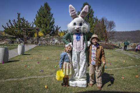 Two children standing with Easter bunny.