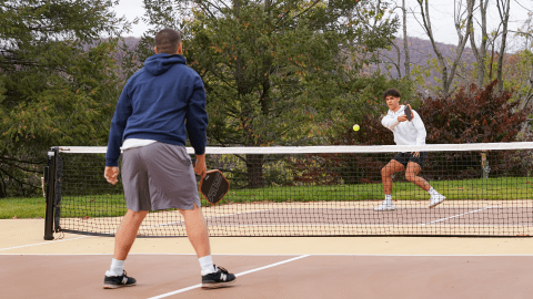 Two boys playing pickleball.
