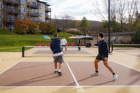 Four men playing pickleball.