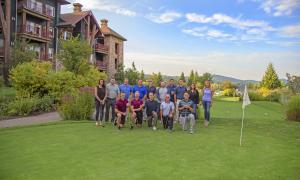 Group of people pose for photo on putting course.