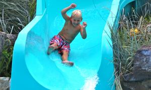 Boy sliding down pool slide at vista 180.