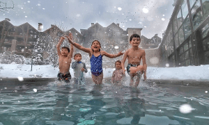 Kids jumping into snow pool at Grand Cascades Lodge 