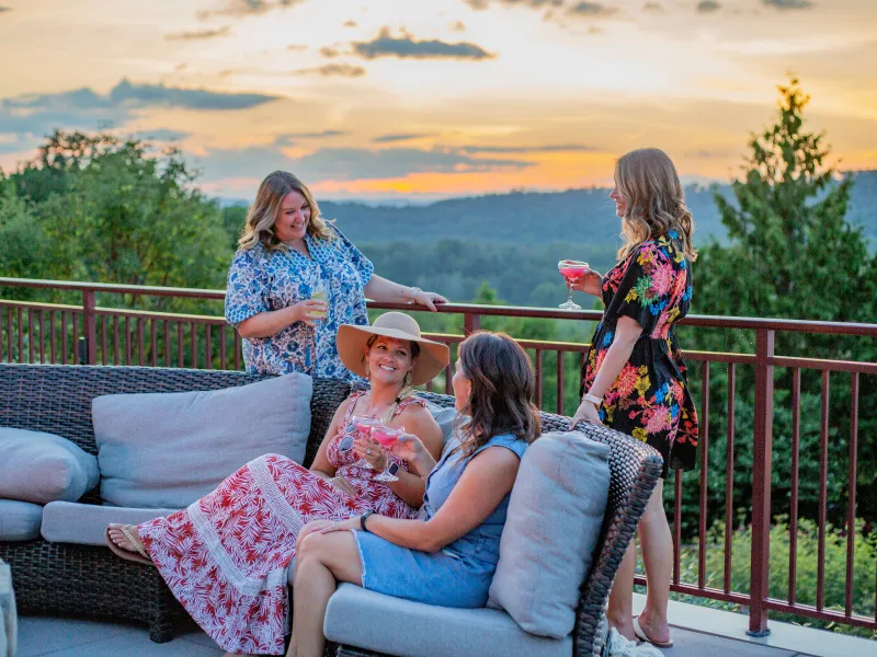Four girlfriends have drinks on Fire & Water Terrace. 